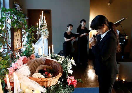 A staff prays in front of an altar for a pet dog during a demonstration of pet funeral services at the Pet Rainbow Festa, a pet funeral expo targeting an aging pet population, in Tokyo, Japan September 18, 2017. REUTERS/Kim Kyung-Hoon