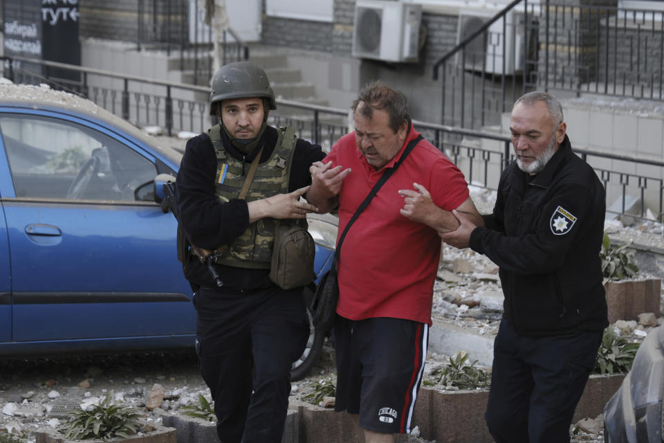 Police officers help an injured man evacuate from a multi-story apartment building to an ambulance during a wave of bombardments targeting in Kyiv, Ukraine, Tuesday, May 30, 2023. (AP Photo/Alex Babenko)