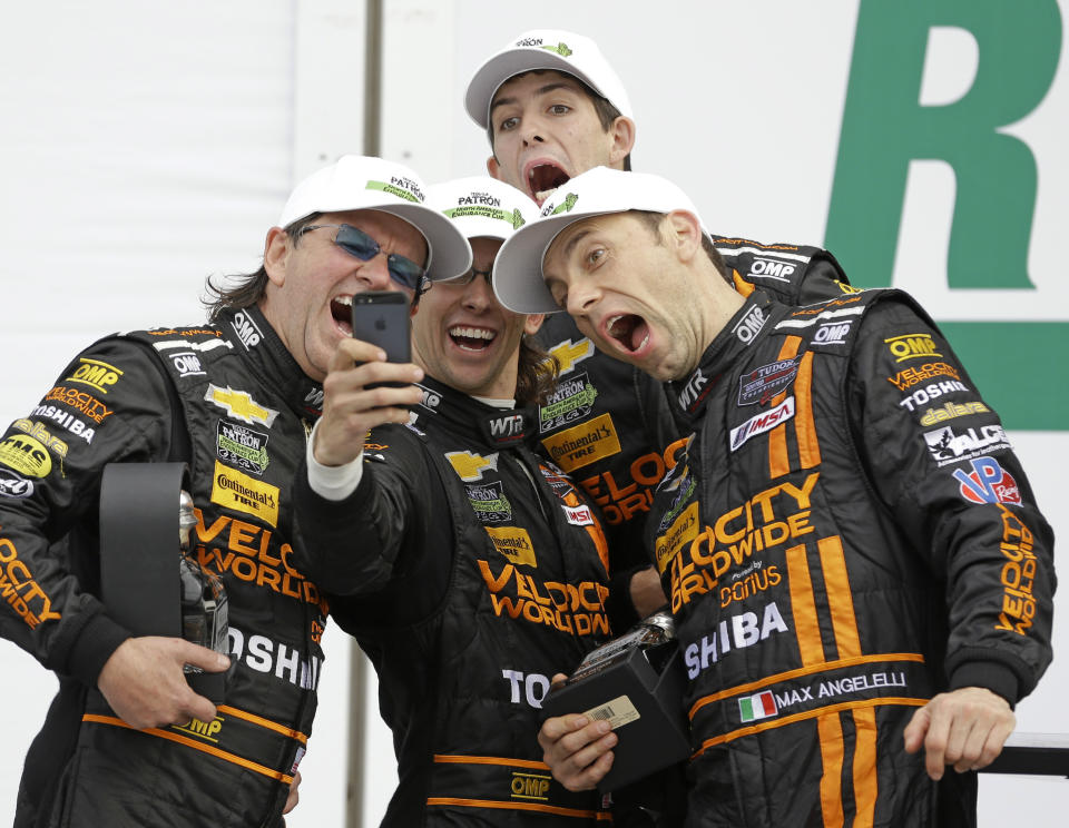 The Wayne Taylor Racing team, from left, Wayne Taylor, Jordan Taylor, Ricky Taylor and Max Angelelli, of Italy, take a group photo to celebrate their second place finish in the IMSA Series Rolex 24 hour auto race at Daytona International Speedway in Daytona Beach, Fla., Sunday, Jan. 26, 2014.(AP Photo/John Raoux)