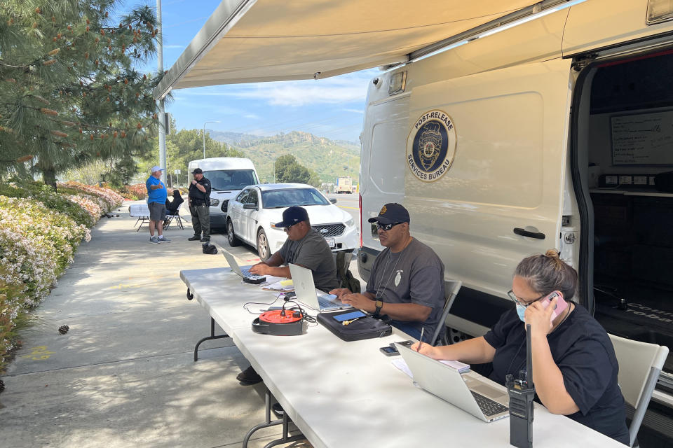 Probation officers waiting to meet with former inmates, who recently left prison, in front of a Los Angeles County Probation Department’s mobile resource center van site in Sylmar, Calif.  (Simone Weichselbaum / NBC News)