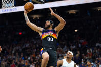 Phoenix Suns center JaVale McGee (00) drives past Orlando Magic guard Gary Harris, right, to score during the first half of an NBA basketball game Saturday, Feb. 12, 2022, in Phoenix. (AP Photo/Ross D. Franklin)