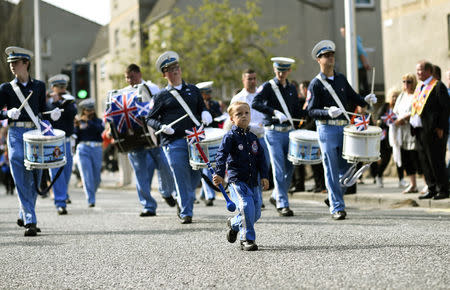 A boy walks in front of band members during a pro-Union rally in Edinburgh, Scotland September 13, 2014. REUTERS/Dylan Martinez