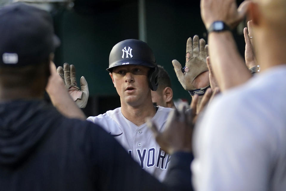 New York Yankees' DJ LeMahieu, center, celebrates in the dugout after hitting a solo home run against the Texas Rangers during the second inning of a baseball game Thursday, April 27, 2023, in Arlington, Texas. (AP Photo/Tony Gutierrez)