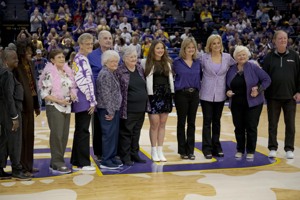 LSU head coach Kim Mulkey, third from right, honors her former coaches as she gave all of her former coaches or their relatives a LSU national championship ring during halftime of an NCAA basketball game against Mississippi Valley State on Sunday, Nov. 12, 2023 in Baton Rouge, La. (AP Photo/Matthew Hinton)