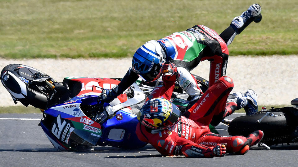 Jack Miller and Alex Marquez are pictured sliding across the track after colliding at the Australian GP.