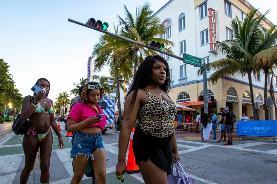 A group of vacationers from Washington, D.C., passes 10th Street as they stroll up Ocean Drive on the first day of Memorial Day weekend in Miami Beach, Florida, on Friday, May 27, 2022.