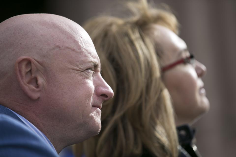 Former astronaut Mark Kelly and his wife, former U.S. Rep. Gabrielle Giffords, look on during the memorial dedication at El Presidio Park in Tucson on Monday, Jan. 8, 2018. The dedication was held on the 7 year anniversary of the Tucson mass shooting that left 6 people dead and 13 others injured including Giffords. The memorial is expected to be completed within the next two years.