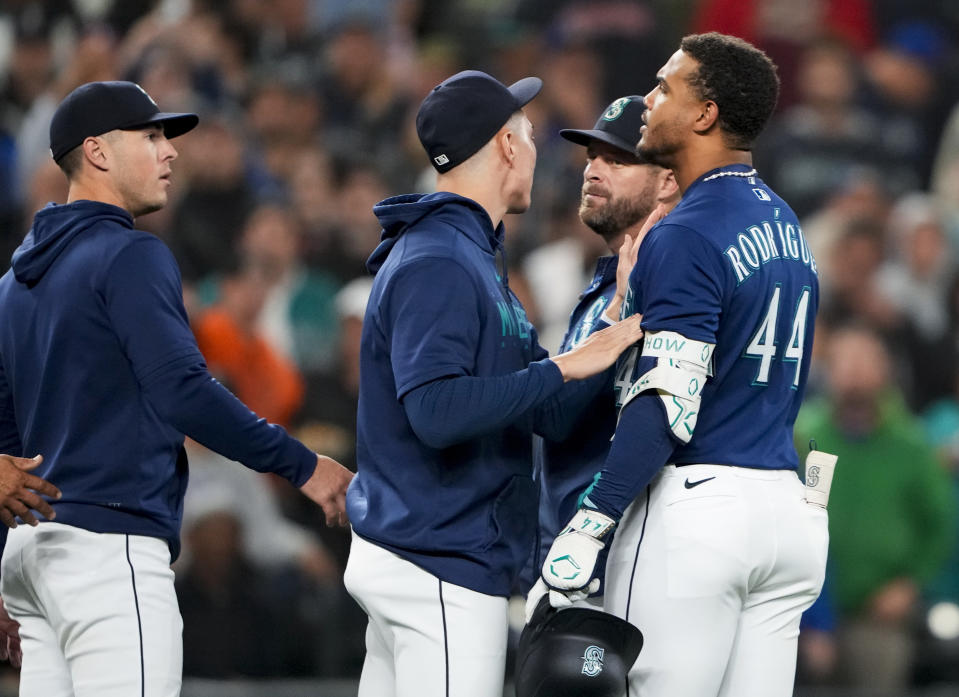 Seattle Mariners' Julio Rodriguez (44) is held back by teammate Bryan Woo, center, as Dylan Moore, left, looks on as benches clear after Rodriguez struck out against Houston Astros relief pitcher Hector Neris during the sixth inning of a baseball game Wednesday, Sept. 27, 2023, in Seattle. (AP Photo/Lindsey Wasson)