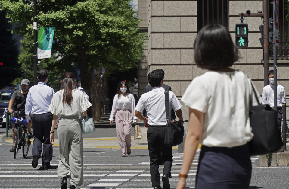 People wearing face masks to help curb the spread of the coronavirus cross an intersection in Tokyo Thursday, Aug. 5, 2021. Tokyo reported 5,042 new daily coronavirus cases on Thursday, hitting a record since the pandemic began as the infections surge in the Japanese capital hosting the Olympics. (AP Photo/Kantaro Komiya)