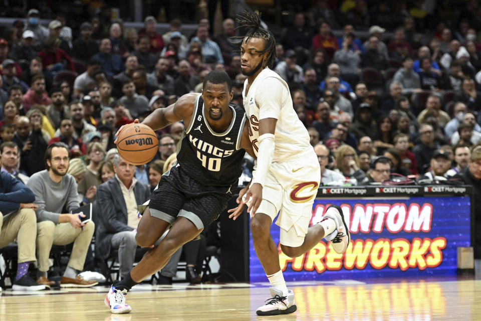 Sacramento Kings forward Harrison Barnes, left, drives against Cleveland Cavaliers guard Darius Garland, right, during the second half of an NBA basketball game, Friday, Dec. 9, 2022, in Cleveland. (AP Photo/Nick Cammett)