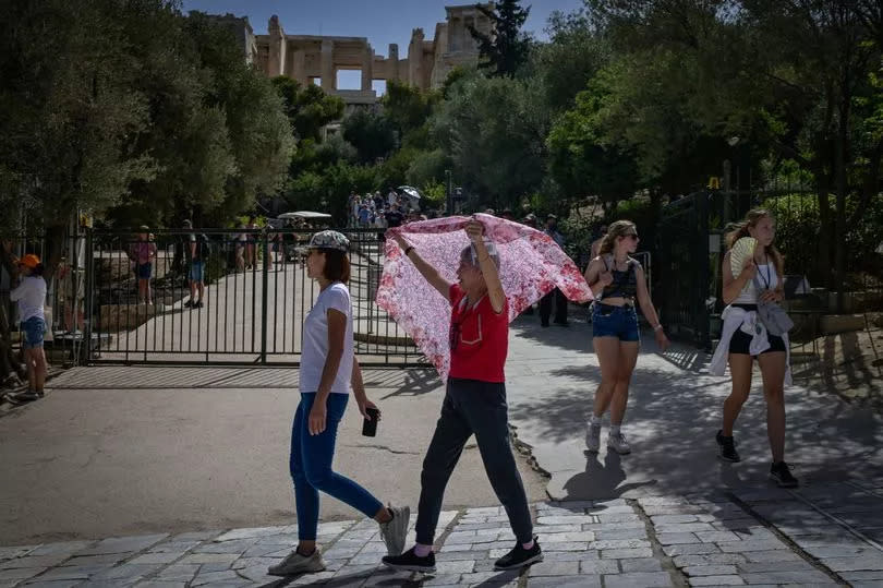 Tourists leave after visiting the ancient Acropolis hill during a hot day in Athens