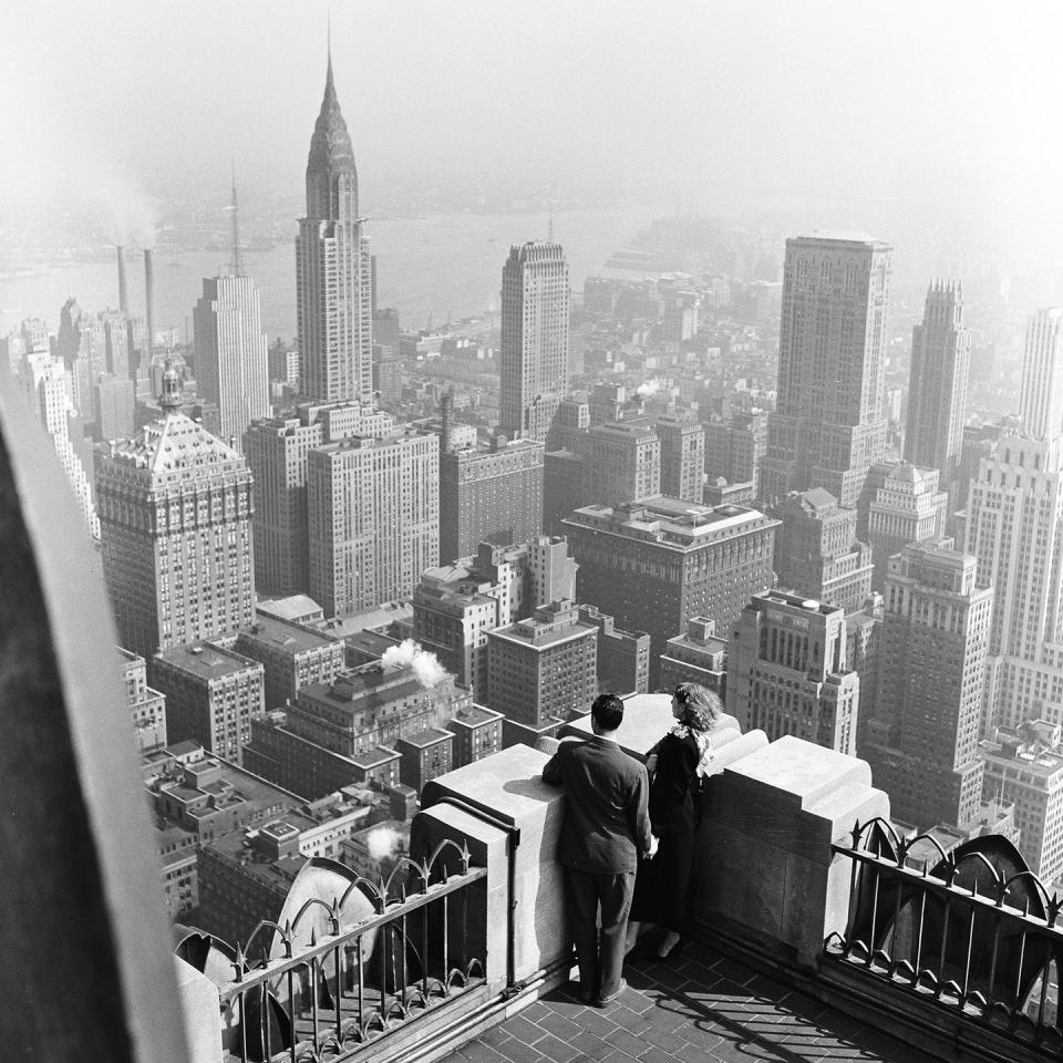 <p>A couple stands on the roof of a manhattan building with a view of the Chrysler Building. Completed in 1930, the art deco building was the tallest building in the world, until the Empire State Building was constructed in 1931. </p>