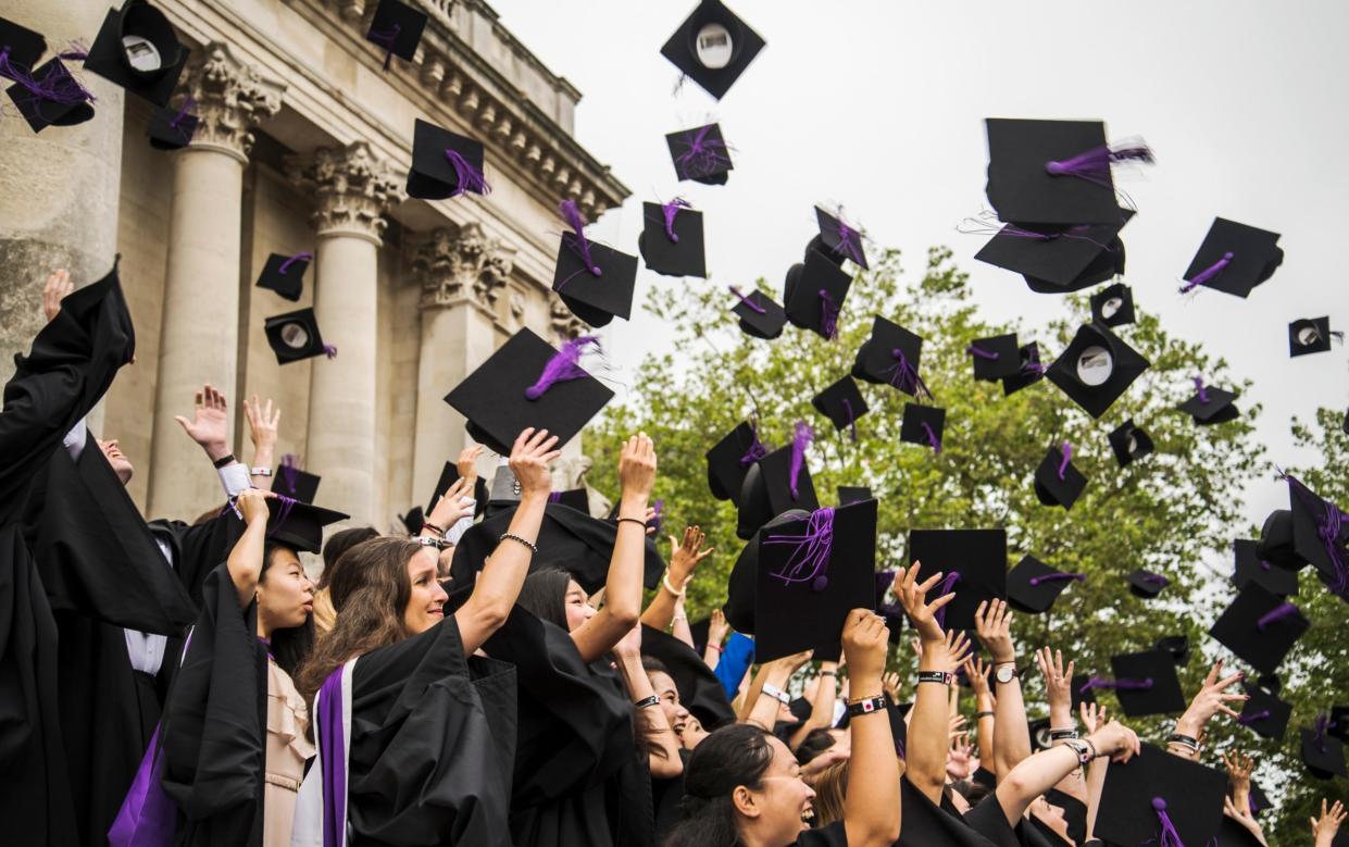 Students graduating throw their academic caps in the air