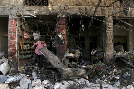 A man inspects damaged shops after an airstrike on a market in the town of Maarat al-Numan in the insurgent stronghold of Idlib province, Syria April 19, 2016. REUTERS/Ammar Abdullah