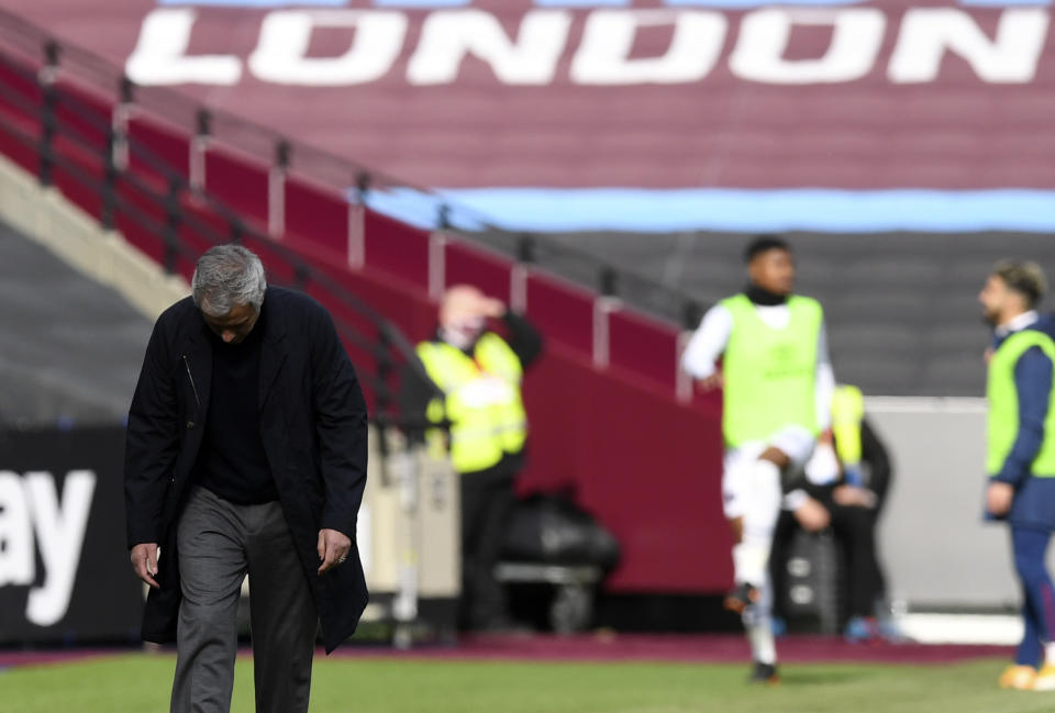 Tottenham's manager Jose Mourinho, left, reacts during the English Premier League soccer match between West Ham United and Tottenham at the London Stadium in London, Saturday, Feb. 21, 2021. (Neil Hall/Pool via AP)