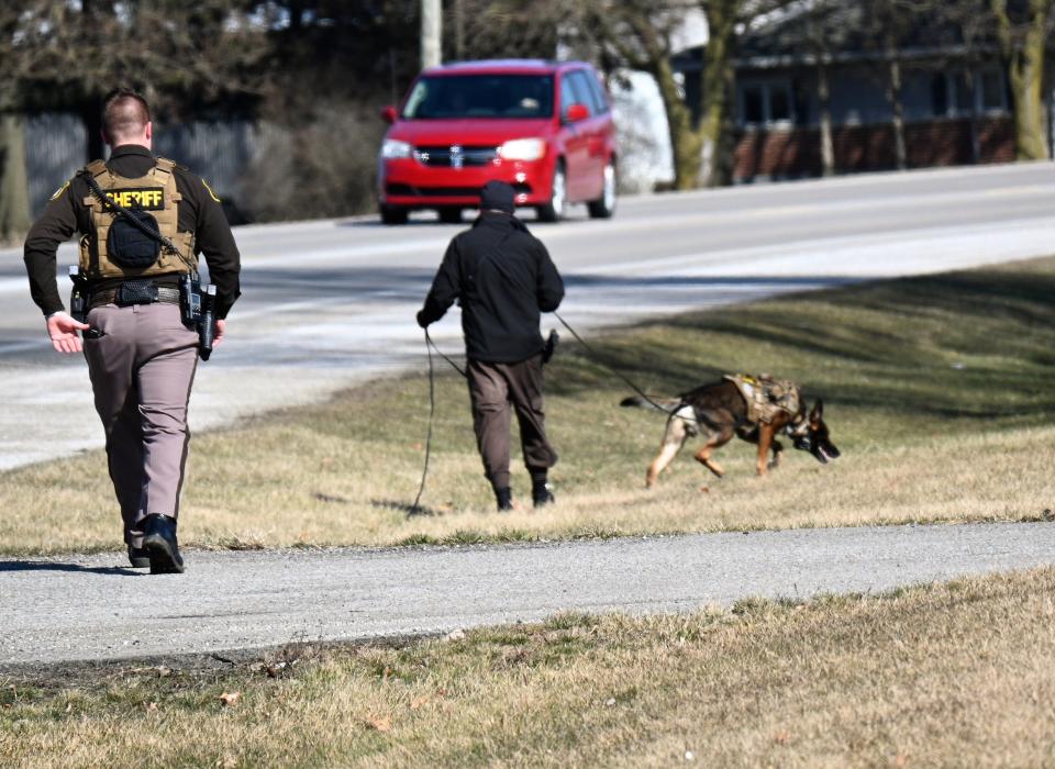 Deputy Dalton Turmell and deputy Scott Jaye with his dog Choas searched for items thrown from the fleeing car along U.S. 12 Sunday.