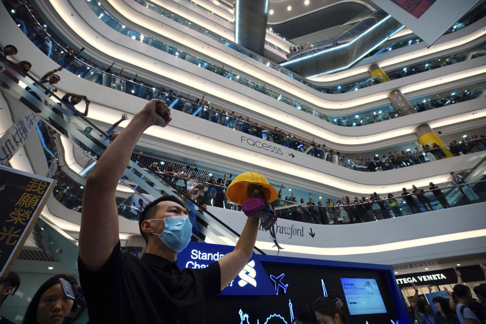 Demonstrators sing a theme song written by protestors "Glory to Hong Kong" at the Times Square shopping mall in Hong Kong, Thursday, Sept. 12, 2019. Thousands of people belted out a new protest song at Hong Kong's shopping malls in an act of resistance that highlighted the creativity of demonstrators in their months-long fight for democratic freedoms in the semi-autonomous Chinese territory. (AP Photo/Vincent Yu)