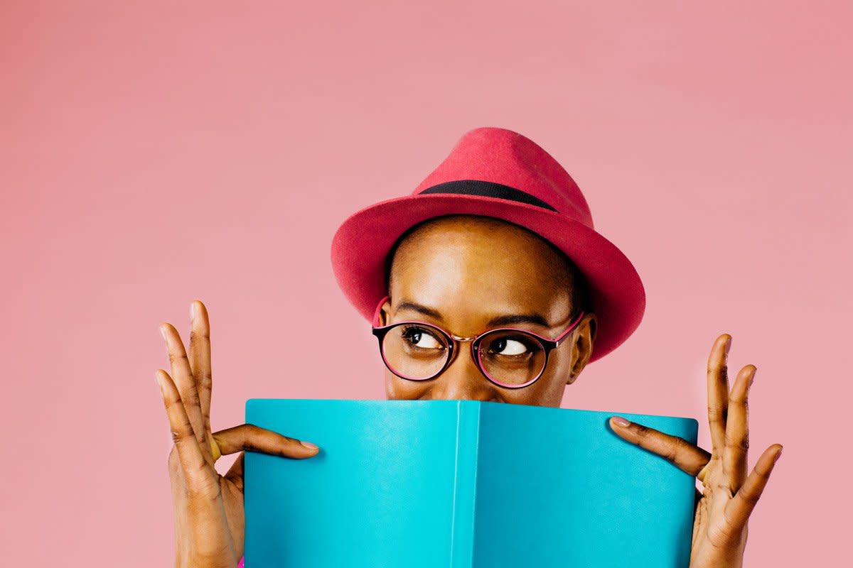 A woman peaks up from a book.