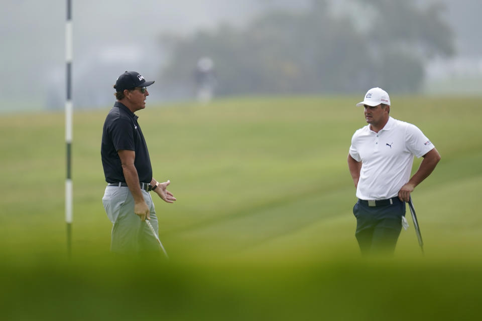 Phil Mickelson, left, talks with Bryson DeChambeau on the 12th hole during a practice round of the U.S. Open Golf Championship Monday, June 14, 2021, at Torrey Pines Golf Course in San Diego. (AP Photo/Gregory Bull)