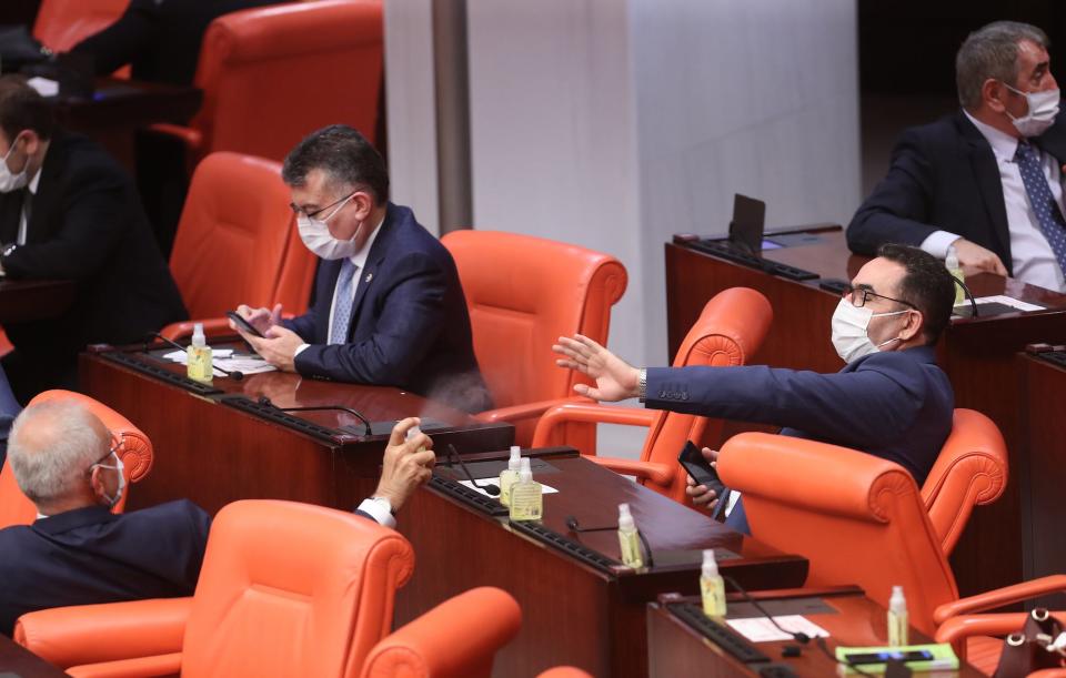 Turkish Members of Parliament wear protective facemasks and share disinfectant gel, as a precaution against the novel coronavirus, during the general assembly meeting of The Grand National Assembly of Turkey in Ankara on April 7.