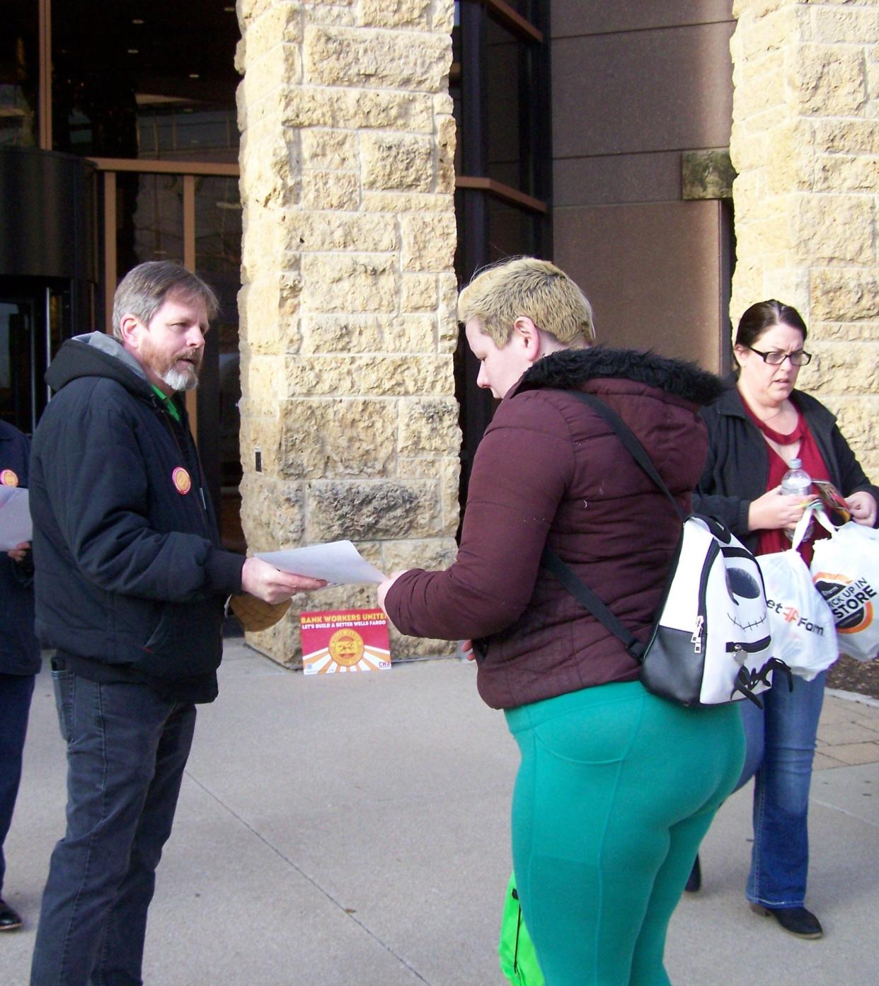 Joe Hertz (left) hands out leaflets promoting a union at Wells Fargo Wednesday morning.