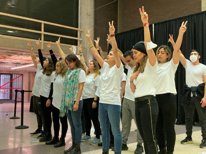 Iranian students raise their arms tearfully as they sing a popular protest song, &quot;Baraye,&quot; on Nov. 15 at UW-Milwaukee. The students staged a demonstration in solidarity with the protests occurring across Iran for human rights and for the end to the current regime.