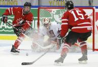 Canada's Connor McDavid (L) makes a pass to Canada's Derrick Pouliot in front of Czech Republic's goalie Marek Langhammer during the first period of their IIHF World Junior Championship ice hockey game in Malmo, Sweden, December 28, 2013. REUTERS/Alexander Demianchuk (SWEDEN - Tags: SPORT ICE HOCKEY)