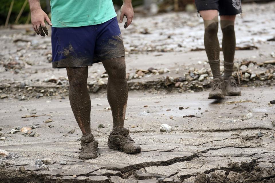 Residents Brooke Horspool, left, and his son Andrew Horspool show mud up to their knees while helping a neighbor in the aftermath of Tropical Storm Hilary Monday, Aug. 21, 2023, in Yucaipa, Calif. | Marcio Jose Sanchez, Associated Press