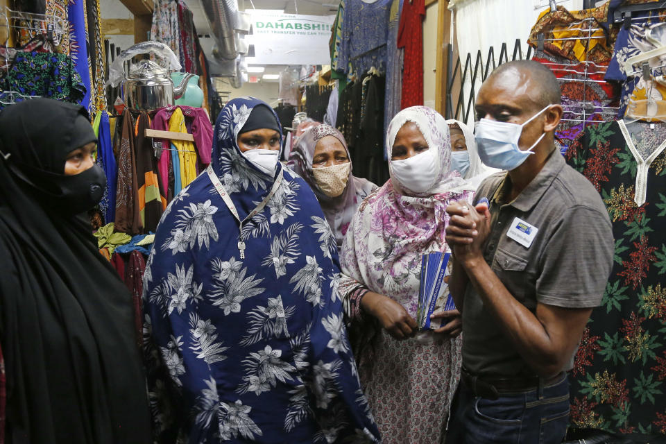 Fifth Congressional District candidate, Democrat Antone Melton-Meaux, right, found support when he took his campaign to unseat Democrat Rep. Ilhan Omar to what should be a stronghold for her, a mall full of shops that cater to Minneapolis' large Somali American community Wednesday, July 22, 2020 in Minneapolis. Melton-Meaux is giving Omar an unexpectedly strong, well-funded primary challenge in one of the country's most heavily Democratic congressional districts, which includes Minneapolis and some suburbs. (AP Photo/Jim Mone)