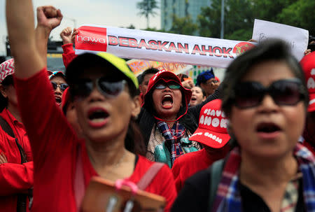 Supporters of former Jakarta Governor Basuki Tjahaja Purnama, or Ahok, hold a placard and shout slogans during a protest in front of North Jakarta District Court in Jakarta, Indonesia February 26, 2018. Placard says: "Freedom for Ahok". REUTERS/Beawiharta