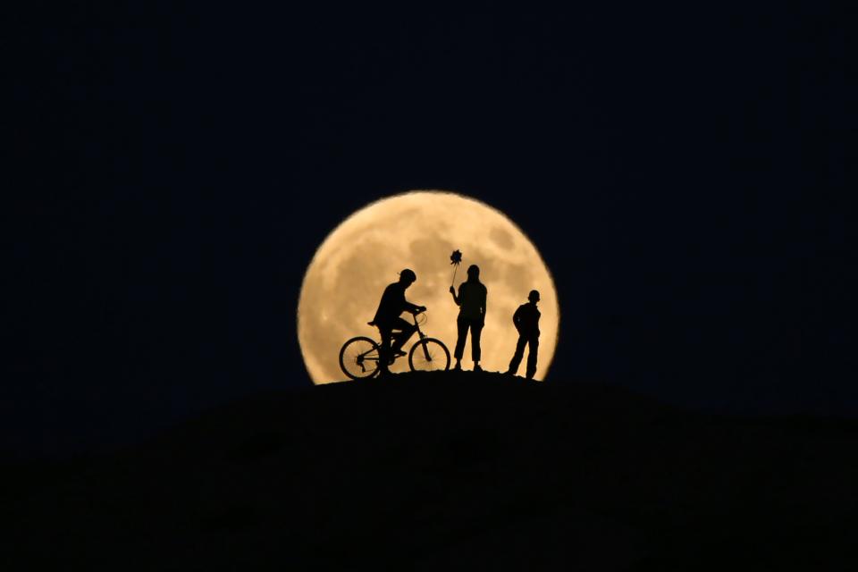 <p>The full moon rises behind silhouettes of people prior to the totally phase of Century’s longest ”Blood Moon” eclipse in Van, Turkey on July 27, 2018. (Photo: Ozkan Bilgin/Anadolu Agency/Getty Images) </p>