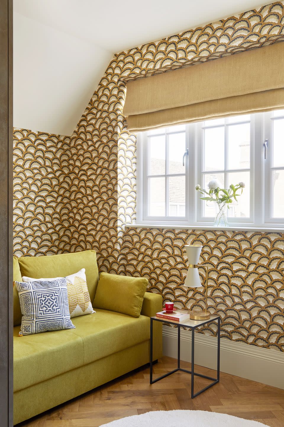 room with gold wallpaper and mustard sofa