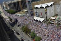 Imagen del sábado 22 de febrero de 2014 que muestra la manifestación de opositores al gobierno de Venezuela realizada en la capital del país, Caracas. Venezolanos opositores y leales al gobierno se movilizaron el sábado luego de más de dos semanas de protestas. (Foto de AP/Carlos Becerra)