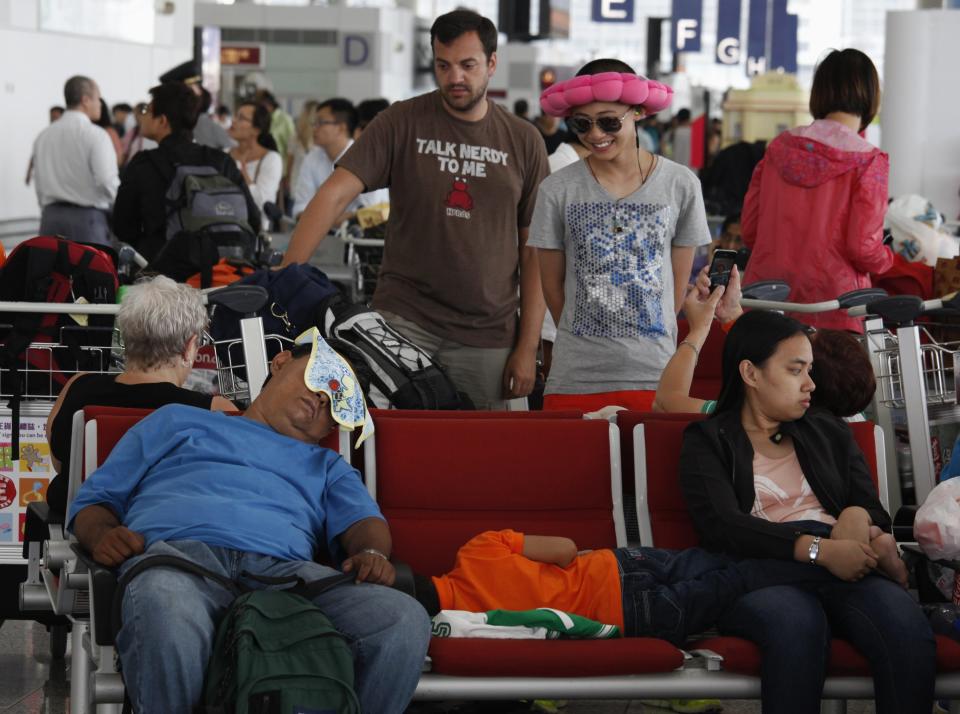 Passengers wait for their departure at Hong Kong Airport after Typhoon Usagi, the strongest storm to hit the Western Pacific this year, swiped Hong Kong September 23, 2013. A powerful typhoon hit Hong Kong and the southern China coast on Monday, killing at least 20 people on the mainland, crippling power lines and causing flooding and gale force winds. More than 370 flights were cancelled. REUTERS/Bobby Yip