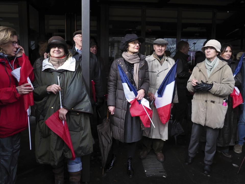 Supporters of conservative presidential candidate Francois Fillon holds French flag, during a rally in Paris, Sunday, March 5, 2017. The rally across from the Eiffel Tower is meant to gauge Fillon's remaining support after numerous defections by conservative allies just seven weeks before the first round of the April-May election. Fillon faces corruption charges. (AP Photo/Thibault Camus)