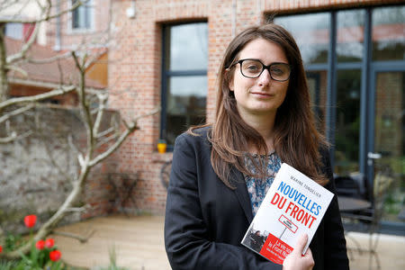 Marine Tondelier, Green party member and local councilor, poses in her garden with her book "Nouvelles du Front" during an interview as part of the 2017 French presidential election campaign in Henin-Beaumont, France, April 6, 2017. REUTERS/Pascal Rossignol