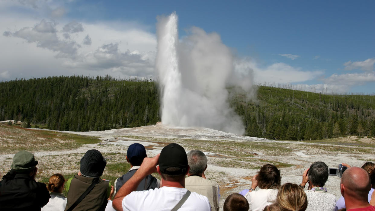  Tourists watching Old Faithful erupt at Yellowstone National Park 