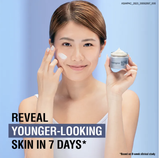 Young lady smearing Neutrogena Rapid Wrinkle Repair Retinol on face and smiling.