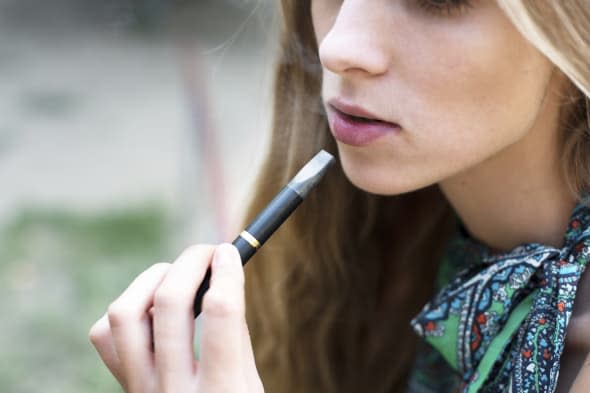 Woman smoking electronic cigarette outdoor