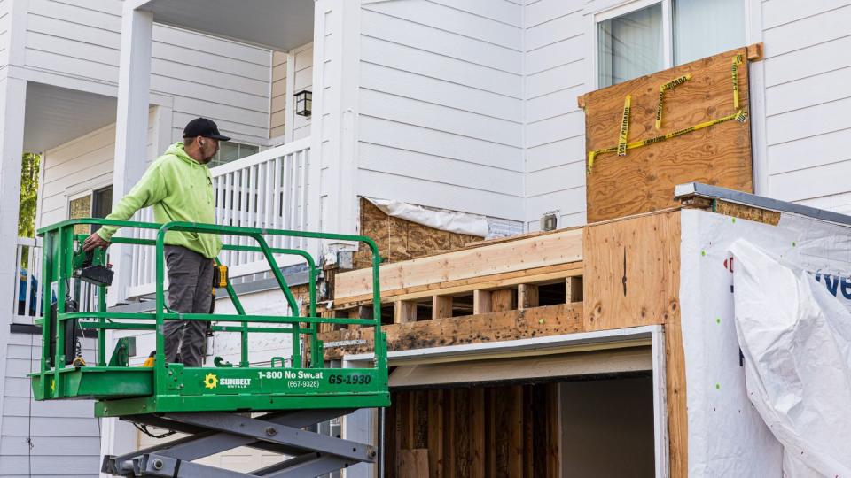 A worker treats wood affected by mold at the back of a townhouse at Joint Base Lewis-McChord. (Dan Delong/InvestigateWest)