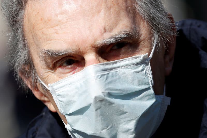 An elderly man wears a protective face mask to prevent contracting the coronavirus in Milan