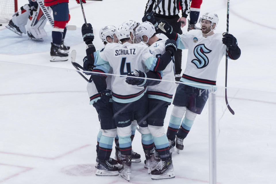 Seattle Kraken defenseman Justin Schultz (4) is congratulated for a goal against the Washington Capitals during the second period of an NHL hockey game Thursday, Jan. 11, 2024, in Washington. (AP Photo/Manuel Balce Ceneta)