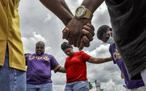 FILE - This photo from Monday June 1, 2020, shows members of the Omega Psi Phi fraternity hold hands in prayer near the site where businesses were destroyed during a night of unrest over the killings of black people by police. The chaos unleashed in 2020, amid the coronavirus pandemic, has created space for different voices to speak, for different conversations to be had and for different questions to be asked. (AP Photo/Chris O'Meara, File)