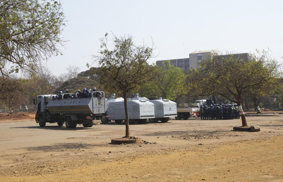 Armed riot police prepare to be deployed on the streets of Harare, Zimbabwe, Friday, Aug. 25, 2023. Hordes of police officers armed with batons, teargas canisters and some with guns were seen next to the result centre as Zimbabweans anxiously waited for the outcome of general elections after polls closed on Thursday and authorities tightened security around the results centre. (AP Photo/Tsvangirayi Mukwazhi)