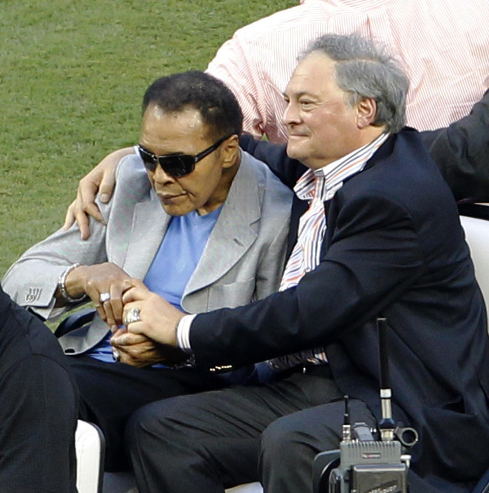 Muhammad Ali, left, rides onto the field with Miami Marlins owner Jeffrey Loria during Opening Day events before a baseball game between the Miami Marlins and the St. Louis Cardinals, Wednesday, April 4, 2012, in Miami. (AP Photo/Wilfredo Lee)