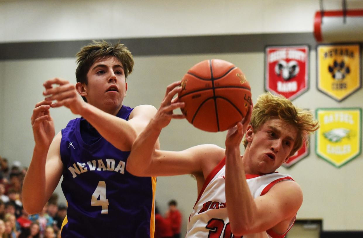 Roland-Story's Ben Greenfield pulls down a rebound in front of Nevada's John Nelson during the first half of the Class 2A No. 4 Norse's 85-80 victory over the Cubs Tuesday in Story City. The win gave Roland-Story a two-game lead in the Heart of Iowa Conference title race.