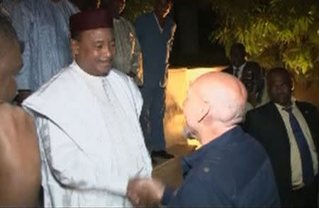 Niger's President Mahamadou Issoufou (L) shakes hands with freed French hostage Serge Lazarevic in Niamey in this still image taken from video December 9, 2014. REUTERS/via Reuters TV