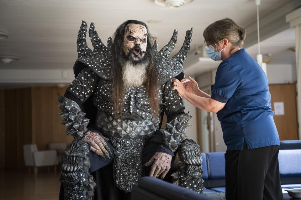 Mr Lordi of the Finnish hard rock band Lordi receives his second Covid-19 vaccination from nurse Paula Ylitalo in Rovaniemi, Finland, Sunday, Aug. 1, 2021. (Jouni Porsanger/Lehtikuva via AP)