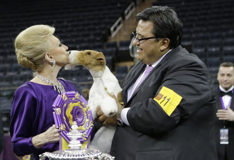 FILE - Judge Betty Regina Leininger, left, and handler Gabriel Rangel, pose with Sky, a wire fox terrier, after winning best in show at the Westminster Kennel Club dog show in New York, in this Tuesday, Feb. 11, 2014, file photo. In a competition that can include a Norwegian elkhound, Australian shepherd and Chinese shar-pei, the people come from all over the world, too. Born in Mexico, Gabriel Rangel is among the most successful handlers in history. (AP Photo/Frank Franklin II, File)