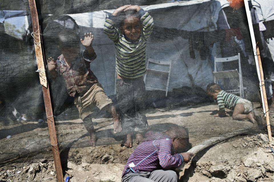 FILE - In this Wednesday, May, 2, 2018, file photo, children play inside the Moria refugee camp on the northeastern Aegean island of Lesbos, Greece. Authorities are to move about 2,000 asylum seekers out of a severely overcrowded migrant camp on the island of Lesbos by the end of September, Greece's government spokesman said on Tuesday, Sept. 18, 2018 as charities slammed conditions in the facility. (AP Photo/Petros Giannakouris, File)